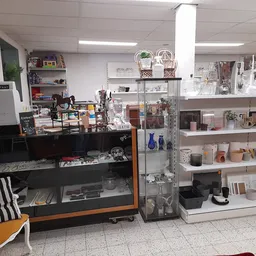 Winkelvloer met vitrinekast, stellingen met servies en decoratie, fauteuil en diverse kringloopwaar