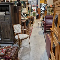 Winkelvloer met houten meubels en diverse tweedehandsartikelen, open ruimte met stellingen en inrichtingsstukken