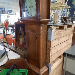 Houten kastmeubel met schildering, naast houten laden en klok