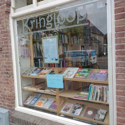 Winkelruit met boeken en spullen uitgestald op houten planken