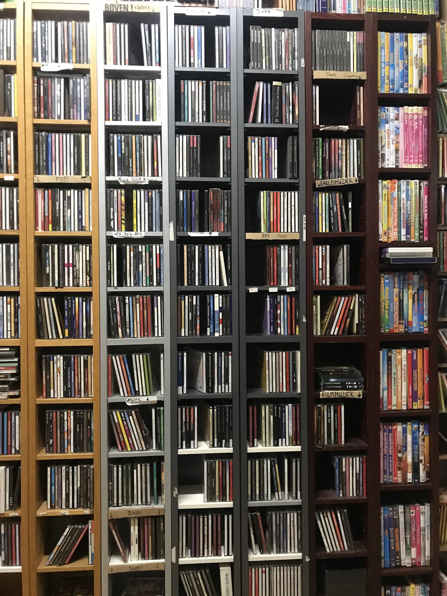 Meerdere boekenkastkasten vol met cd's en dvd's netjes opgesteld in rijen