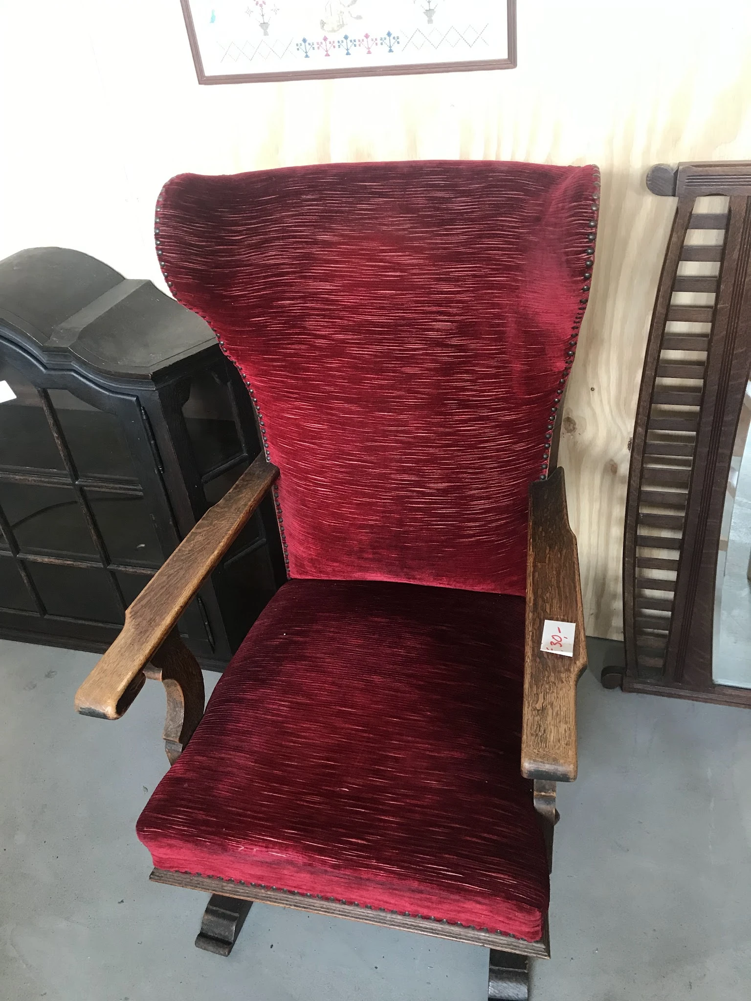 Rood fluweelstoel met houten armleuningen, close-up van zitting en rugleuning
