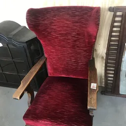 Rood fluweelstoel met houten armleuningen, close-up van zitting en rugleuning