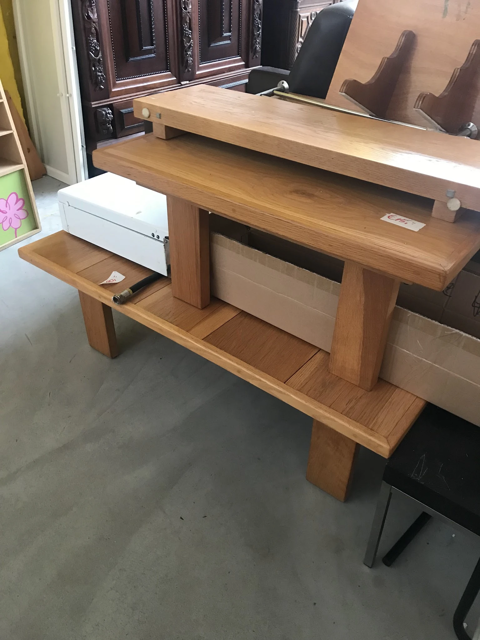 Houten bureau met open vakken en ingebouwde witte lades in kringloopwinkel