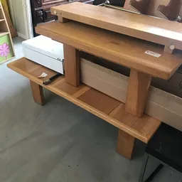 Houten bureau met open vakken en ingebouwde witte lades in kringloopwinkel