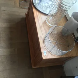 Twee metalen wasteilmanden op een houten tafel