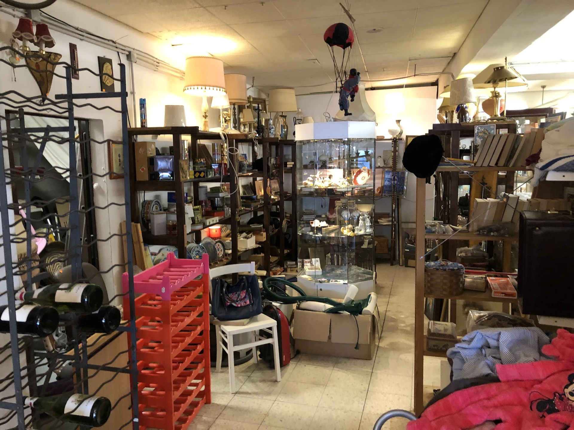 Winkelvloer met stellingen, vitrines, meubels en diversen tweedehands goederen verspreid door de winkel
