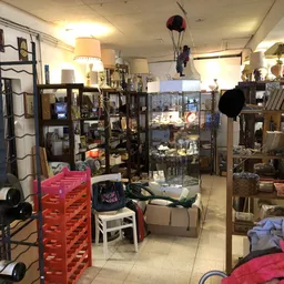 Winkelvloer met stellingen, vitrines, meubels en diversen tweedehands goederen verspreid door de winkel