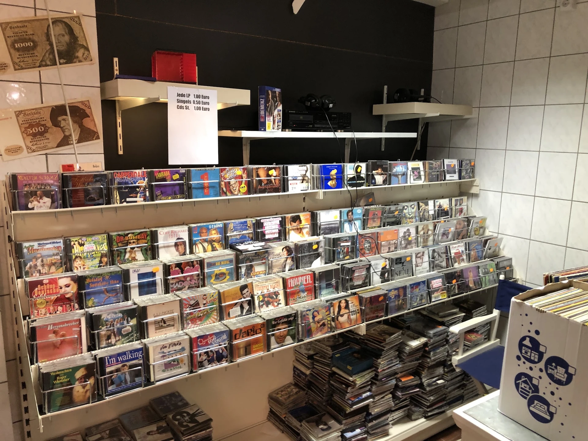 Uitgebreide wandstellingen met honderden cd's, dvd's en andere media netjes uitgestald in een tweedehandswinkel