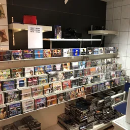 Uitgebreide wandstellingen met honderden cd's, dvd's en andere media netjes uitgestald in een tweedehandswinkel