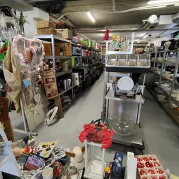 Overzicht van de winkelvloer met stellingen, dozen en diverse tweedehands spullen in de kringloopwinkel