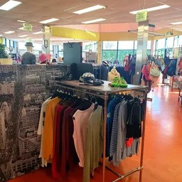 Winkelvloer met kledingrekken en uitgestalde artikelen in een kringloopwinkel