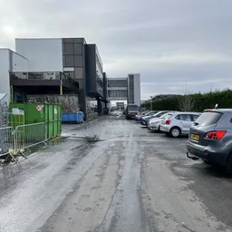 Parkeerterrein met auto's voor industrieel pand van kringloopwinkel Kringkoop