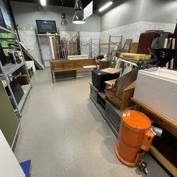 Winkelvloer met houten meubels, stellingen en diverse spullen in een kringloopwinkel