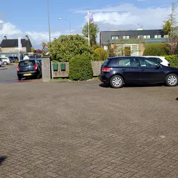 Parkeerplaats met geparkeerde auto's en gebouwen op de achtergrond