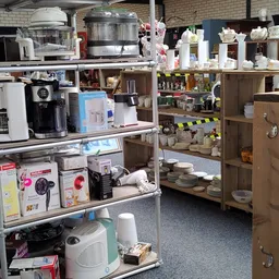 Stellingen met keukenartikelen, servies, huishoudelijke apparaten en diverse gebruiksartikelen in de winkel