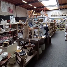 Winkelvloer met stellingen vol huishoudartikelen, servies, kookgerei en decoratie