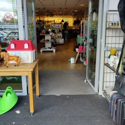 Winkelvloer van een kringloopwinkel met speelgoed, huishoudartikelen en diverse gebruikte goederen uitgestald.