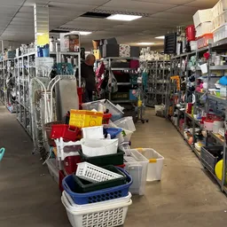 Winkelvloer met plastic bakken en opslagmaterialen, stellingen met diverse artikelen aan beide zijden