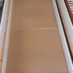 Twee gesloten deuren of panelen met beige/tan kleur en witte kozijnen