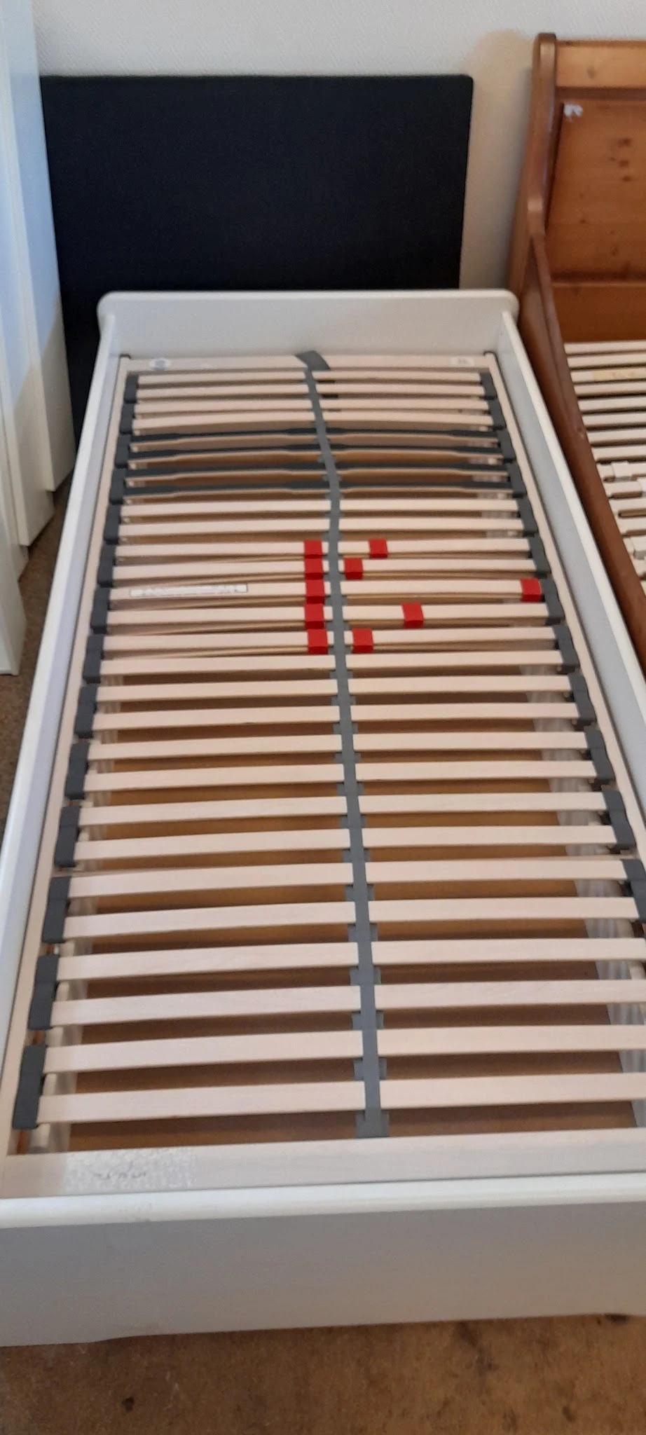 Houten lattenbodem voor bed met rode ondersteuningsstaven