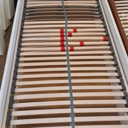 Houten lattenbodem voor bed met rode ondersteuningsstaven