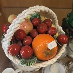 Decoratieve fruitschaal met rode ballen en oranje appels, prijs 20 euro