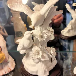 Witte porseleinenfigurine van een vogel op bloemen, close-up detail