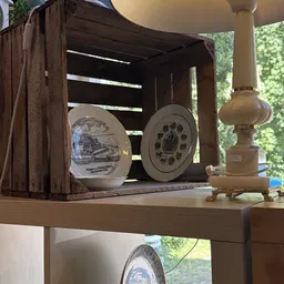 Uitgestalde decoratieve borden en lampen op een plank in de kringloopwinkel