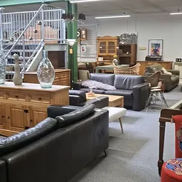 Winkelvloer met meubels: zithoeken met grijze banken, houten kasten, tafels en decoratieve objecten
