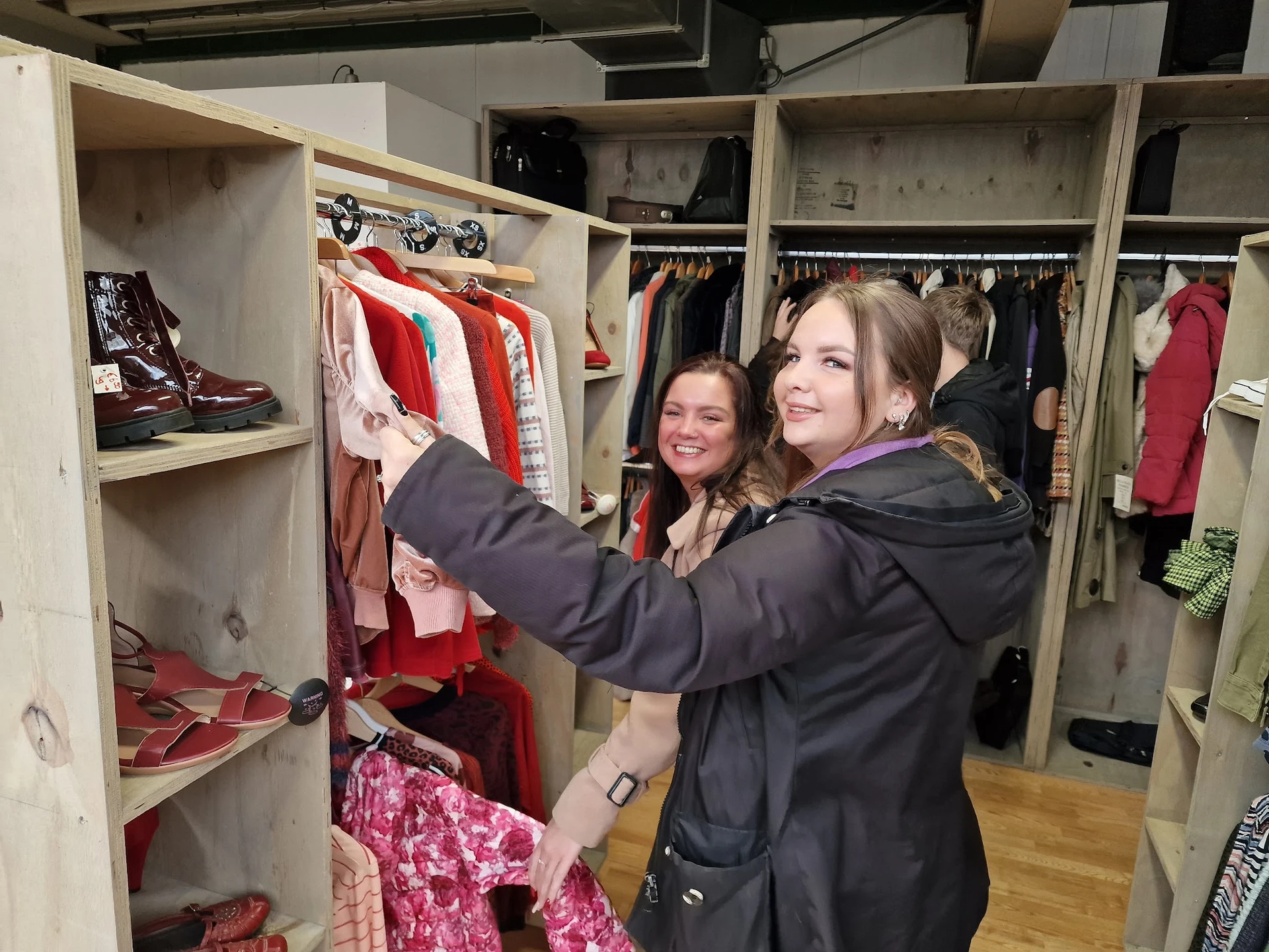 Twee vrouwen selecteren kleding uit een kledingrek in de winkel