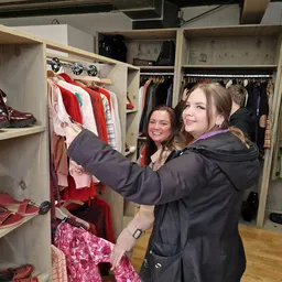 Twee vrouwen selecteren kleding uit een kledingrek in de winkel