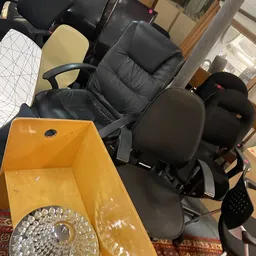 Verschillende kantoorstoelen en meubelen in een kringloopwinkelruimte