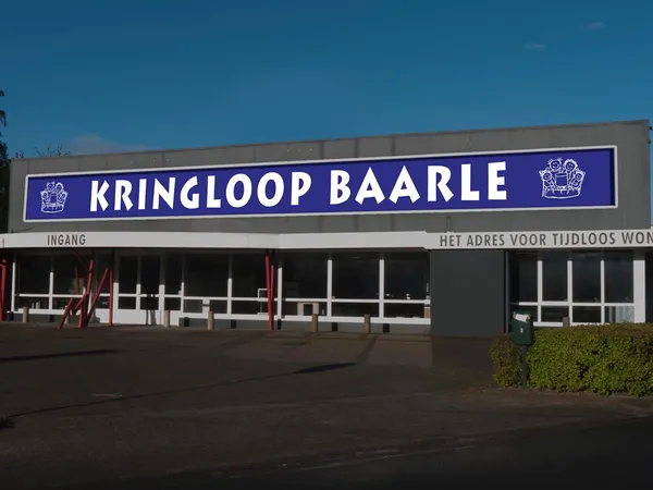 Gevel van Kringloop Baarle met blauwe naambordje en ingang aan de Industrieweg