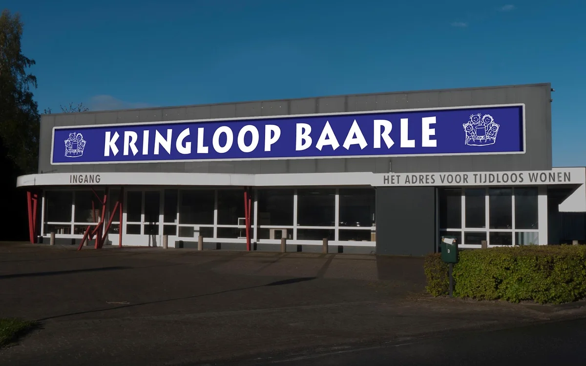 Gevel van Kringloop Baarle met blauwe naambordje en ingang aan de Industrieweg