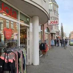 Gevel van kledingwinkel Jola aan een winkelstraat met etalage met kleding