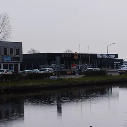 Winkelgevel aan water met parkeerplaats en enkele auto's ervoor