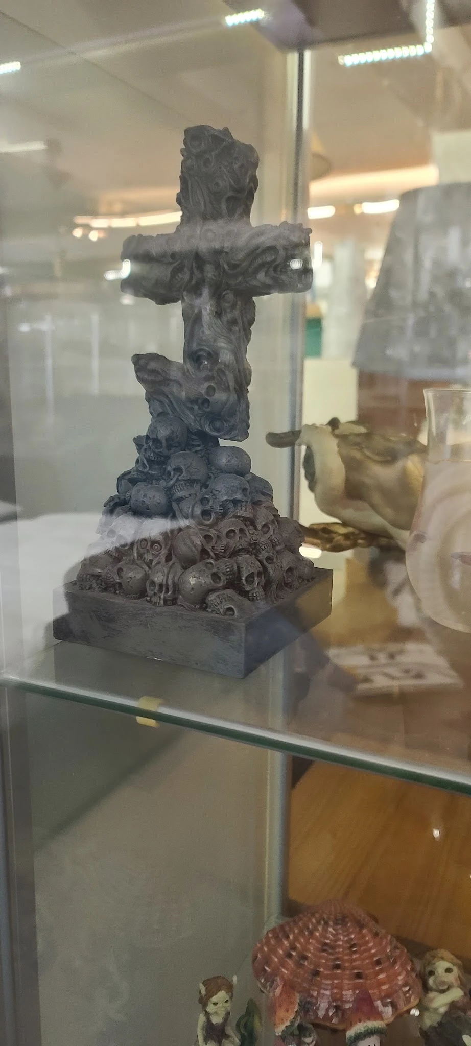 Gesneden stenen sculptuur met gestapelde gezichten en decoratieve elementen op zwart sokkel