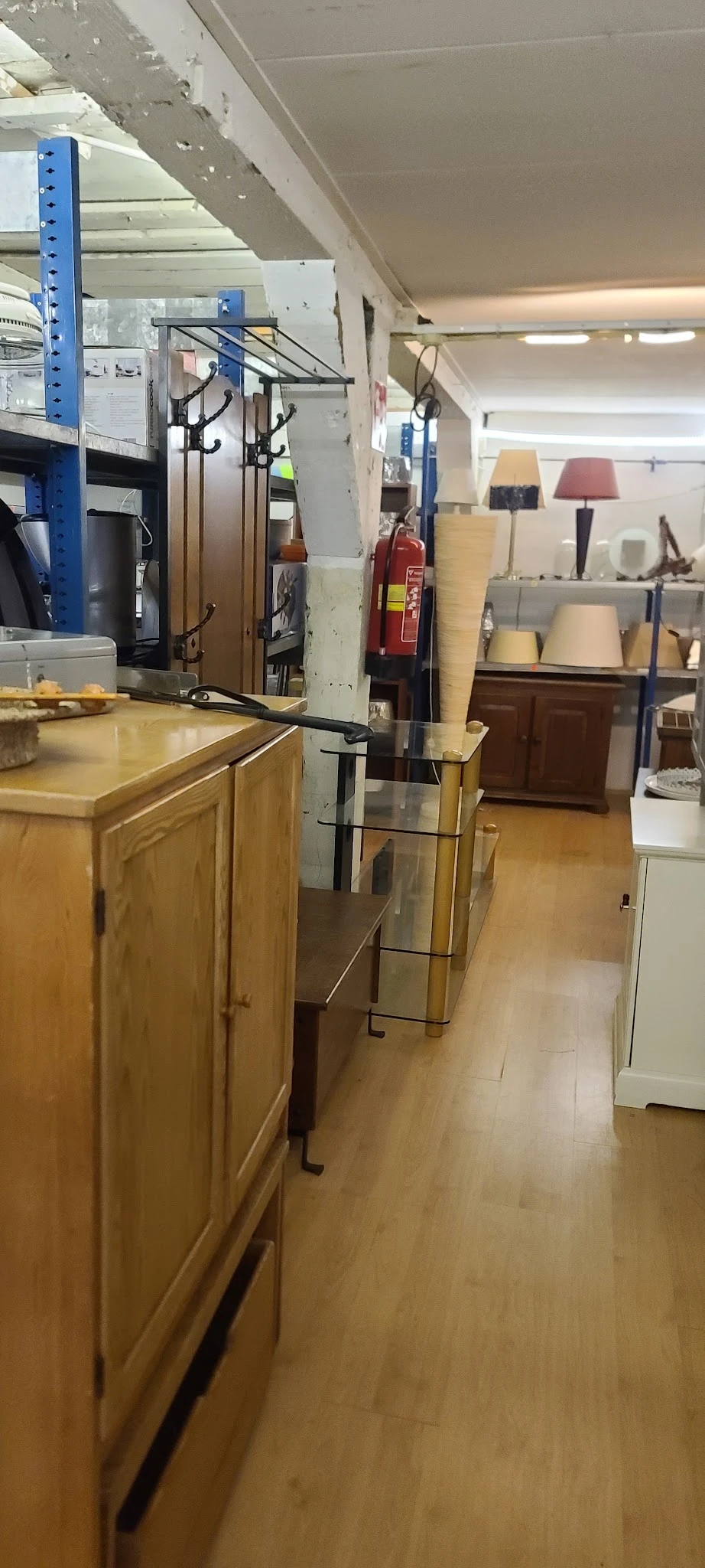Winkelvloer met houten kasten, stellingen en diverse artikelen in een kringloopwinkel