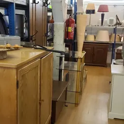 Winkelvloer met houten kasten, stellingen en diverse artikelen in een kringloopwinkel