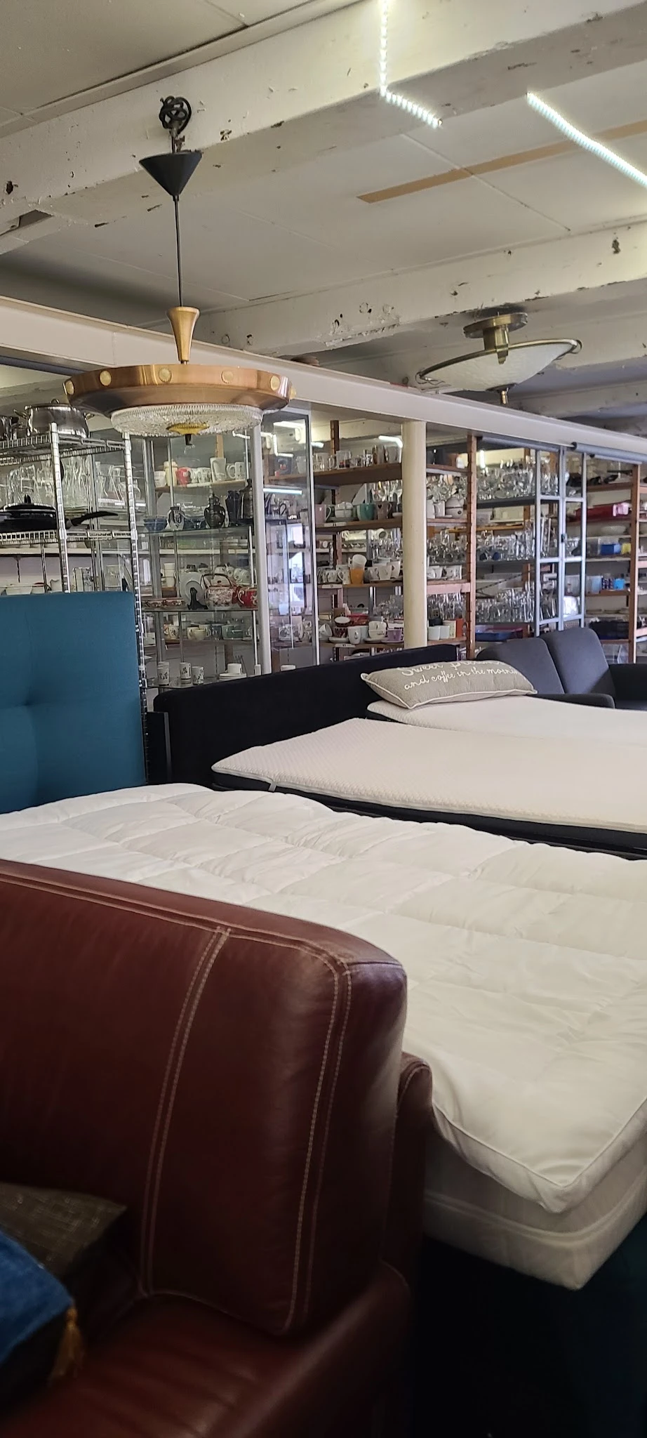 Uitgestalde matrassen en bedden in verschillende maten en kleuren in de winkel