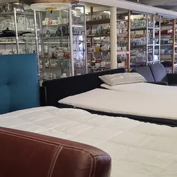 Uitgestalde matrassen en bedden in verschillende maten en kleuren in de winkel