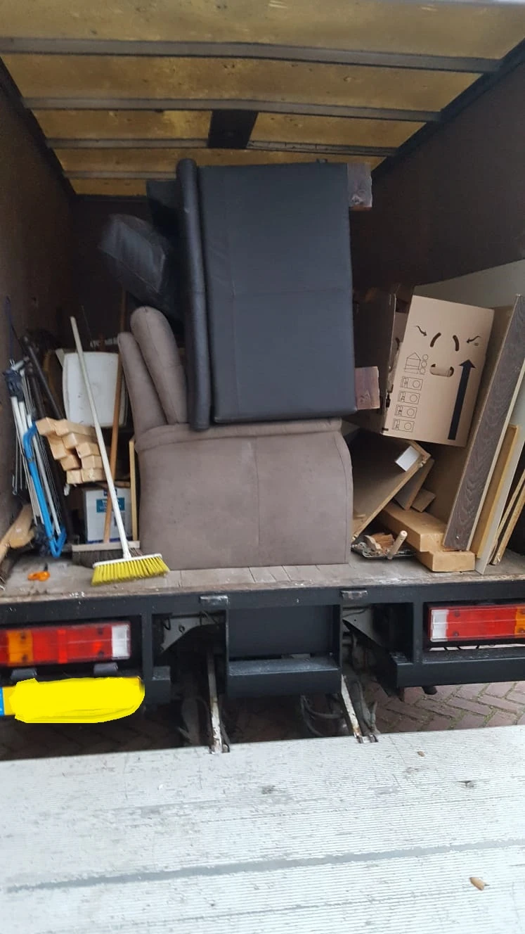 Achterkant van een vrachtwagen vol meubels en huishoudspullen