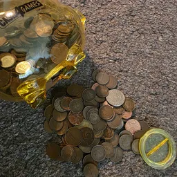Munten en muntenbussen met gele etiketten op grijze ondergrond