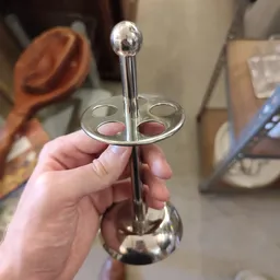 Close-up van een zilveren kandelaar met vier armen, geheven in een hand
