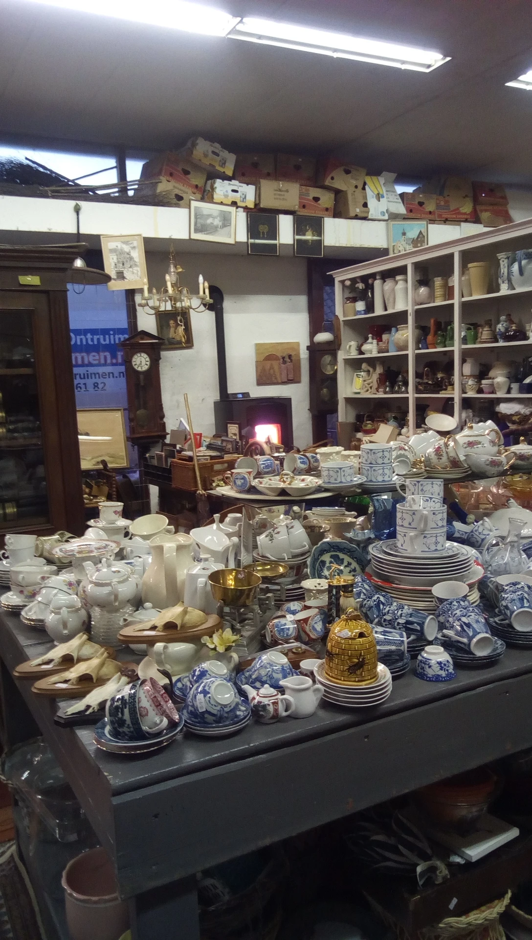 Uitgestalde servies, porselein en huishoudelijke artikelen op tafels in de winkel