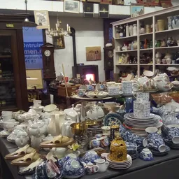 Uitgestalde servies, porselein en huishoudelijke artikelen op tafels in de winkel