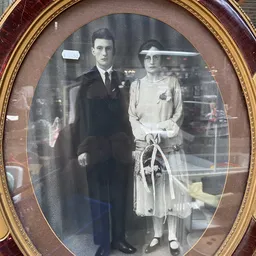 Ingelijste zwart-witfoto van een man in kostuum en een vrouw in jurk met hoed