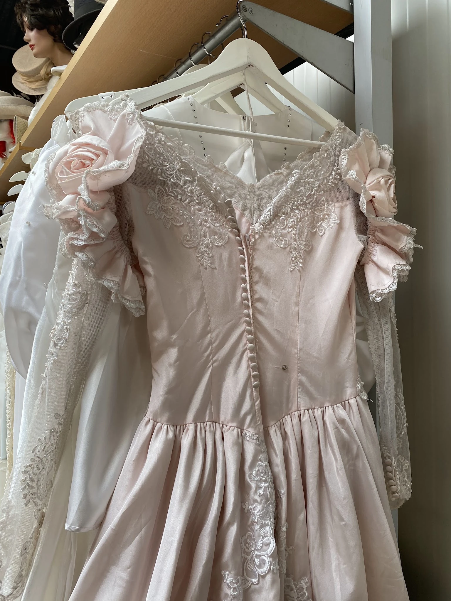 Close-up van een roze vintage bruidsjurk met kant en pofmouwen