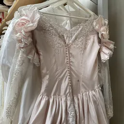 Close-up van een roze vintage bruidsjurk met kant en pofmouwen